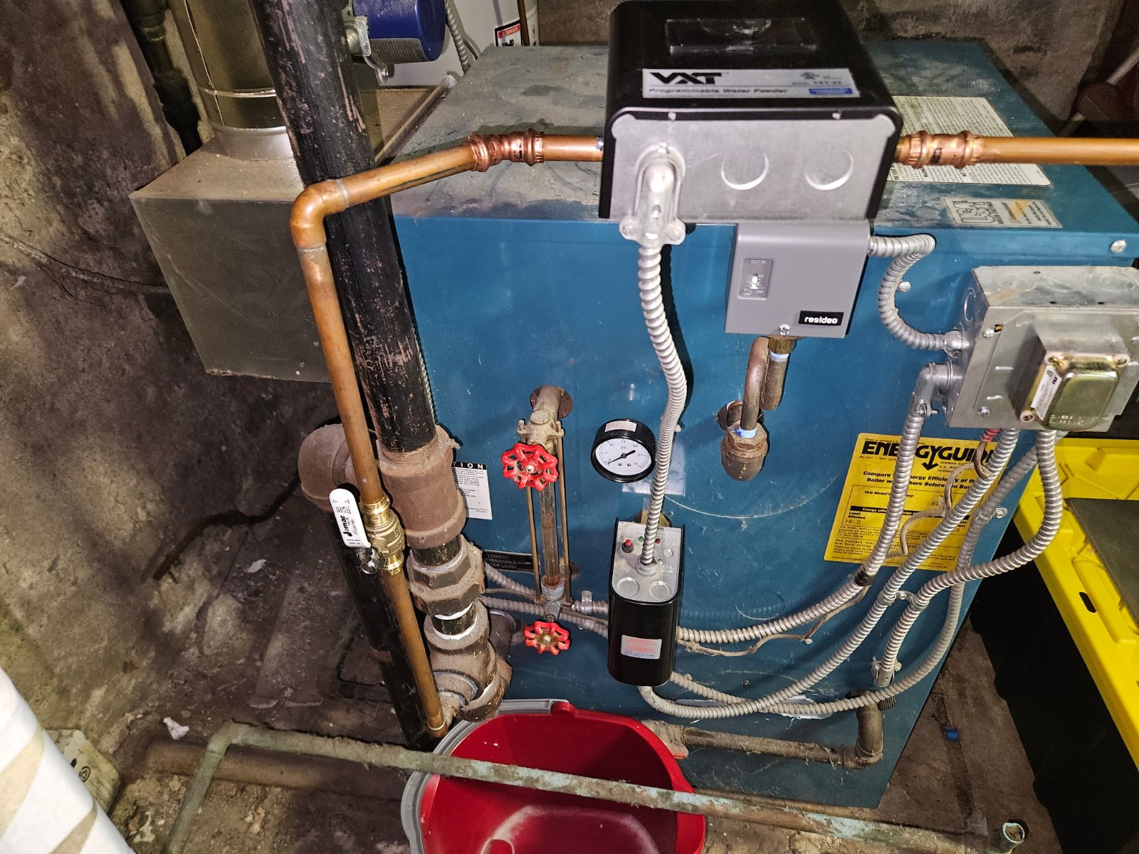Commercial water heating system with copper piping, pressure gauge, and control panel mounted on blue base